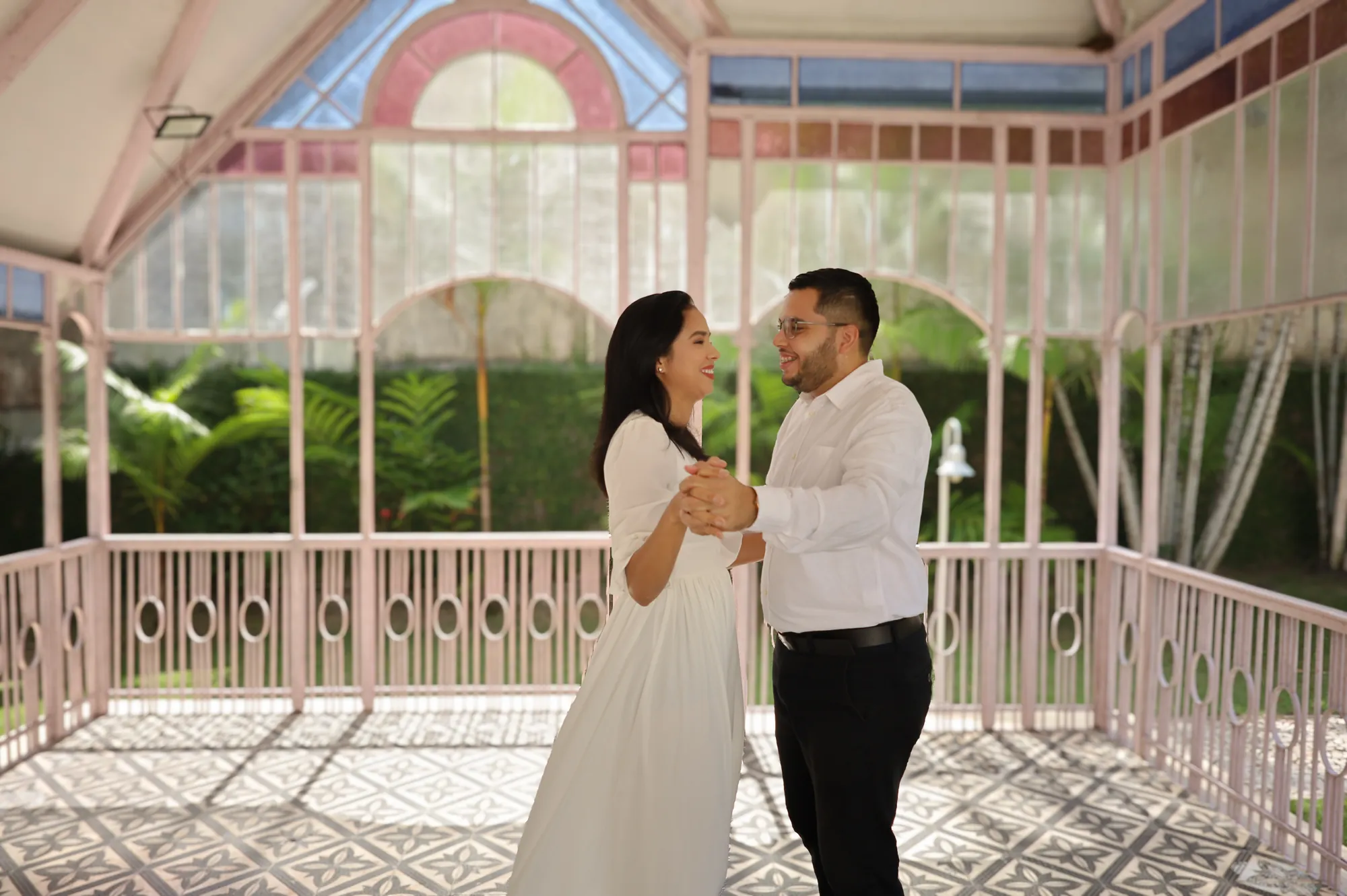 Casal dançando em um pavilhão de vidro rosa, ensaio pré-wedding em Belém
