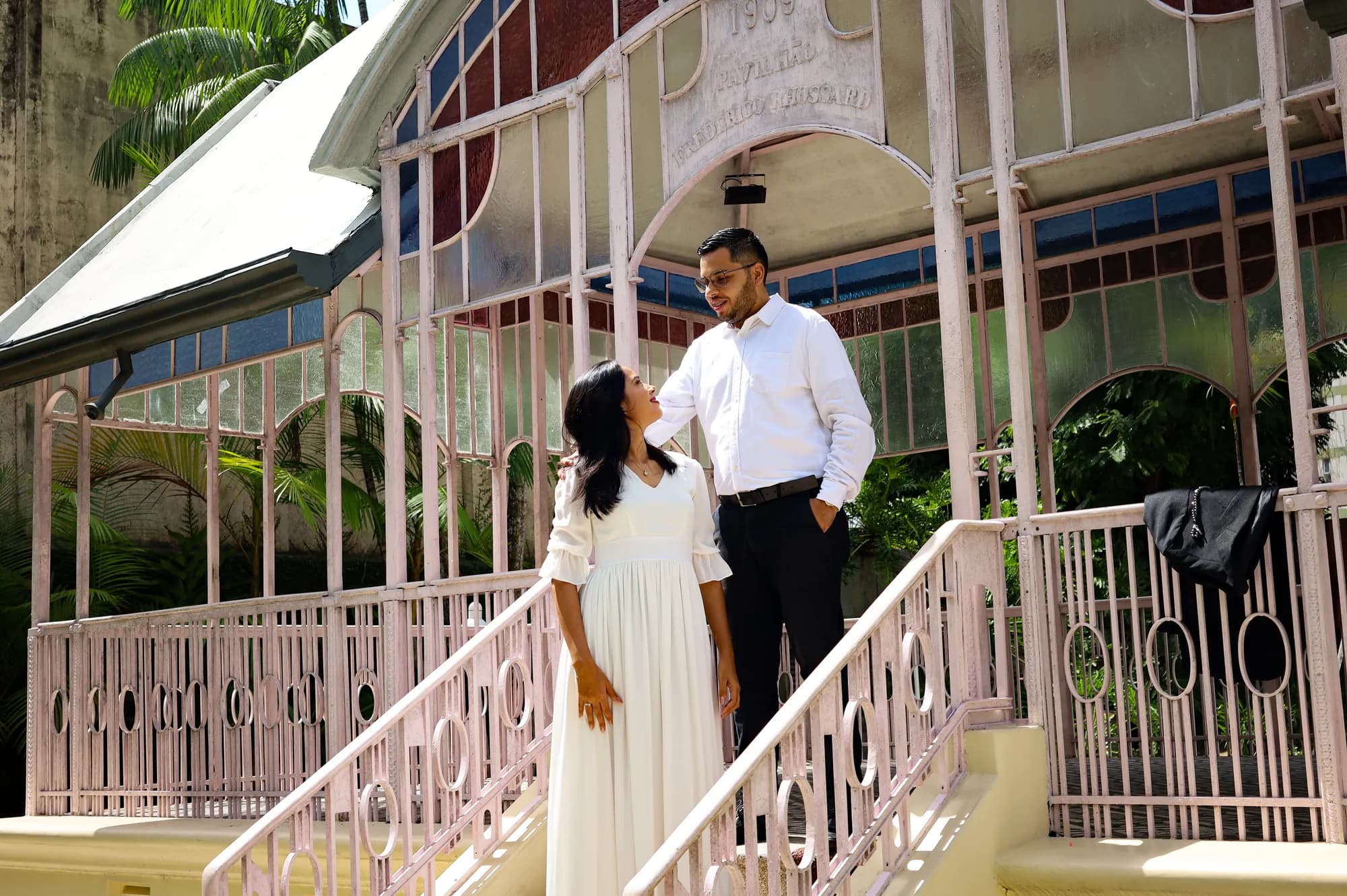 Casal conversando na escada do pavilhão rosa
