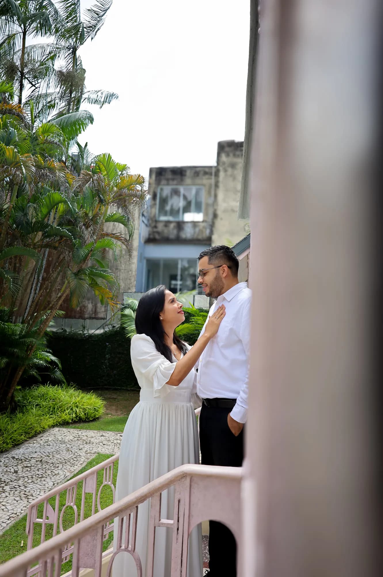 Casal abraçado em um jardim ao lado do pavilhão