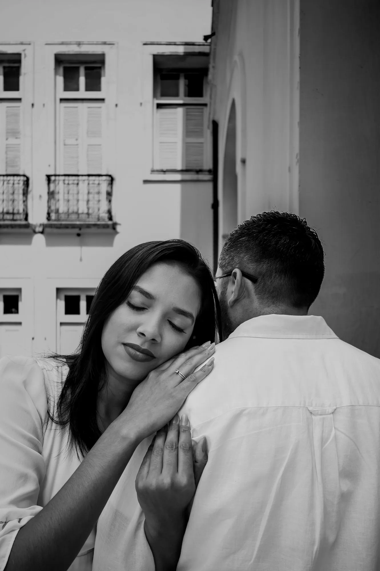 Retrato em preto e branco de noiva de olhos fechados, apoiada no parceiro