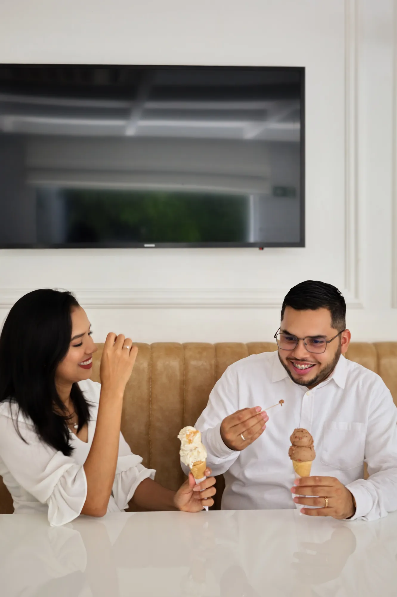 Casal sorrindo enquanto toma sorvete