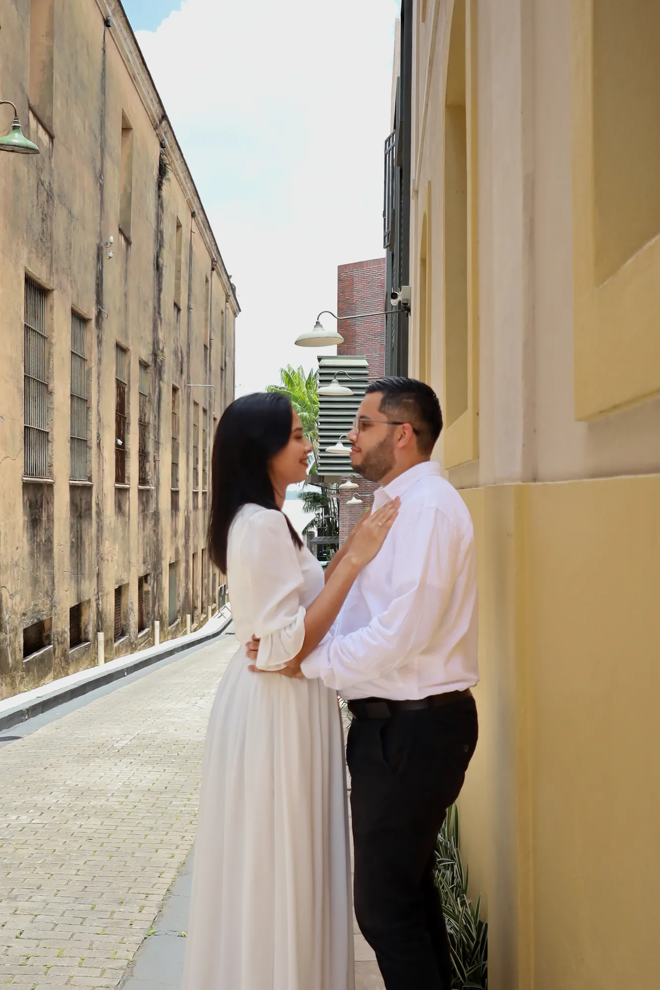 Casal abraçado em rua estreita entre casarões históricos