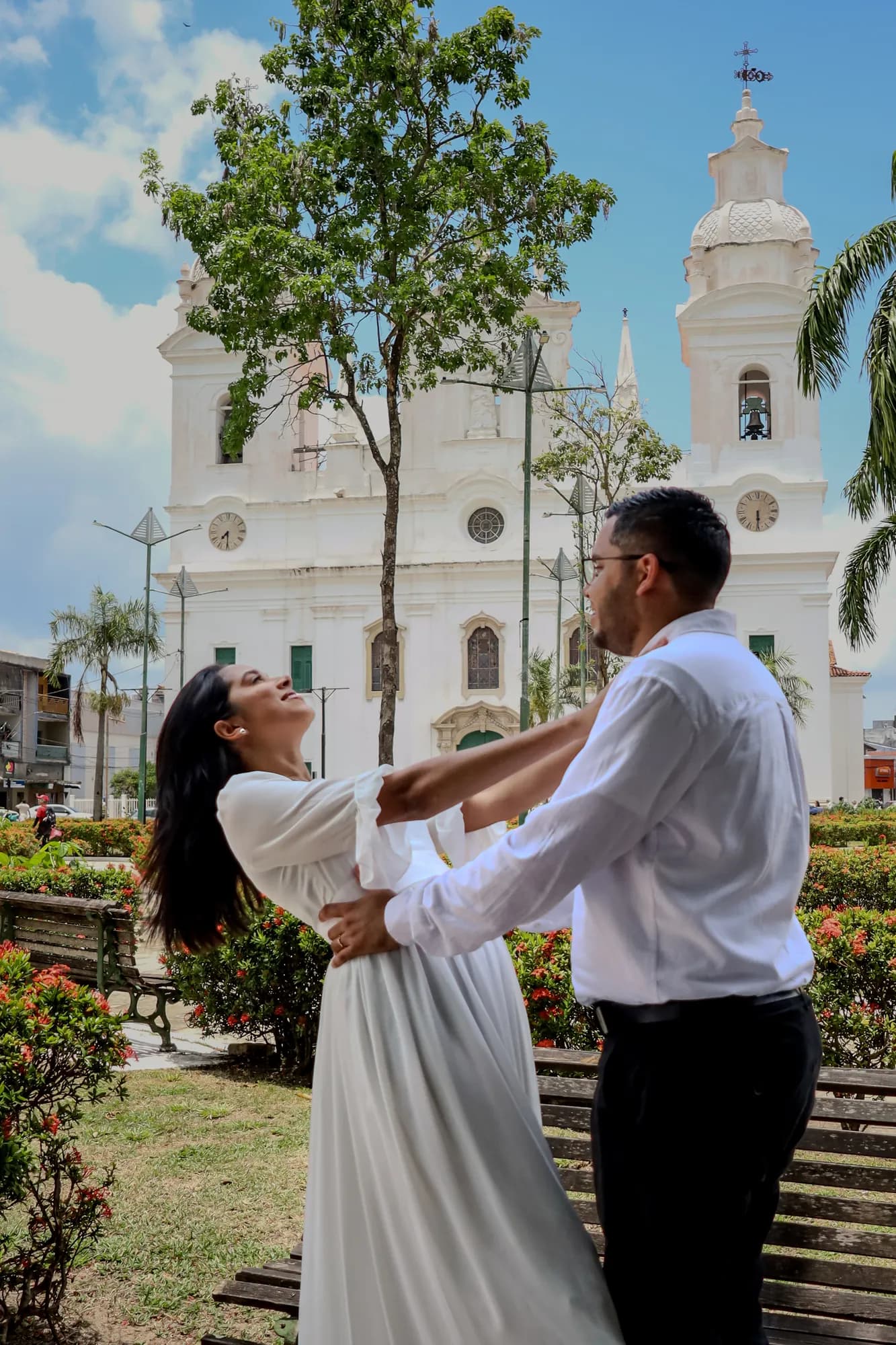 Casal dançando em uma praça de Belém diante de igreja branca